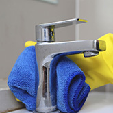 Main nettoyant un mitigeur chromé